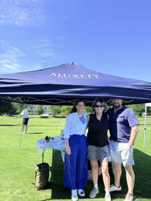Adeline Matton, Noreen Suleski, Henry Pizzo standing under Aluxety tent