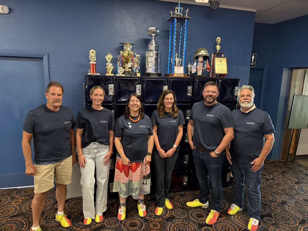 Aluxety Agents standing in front of bowling trophies